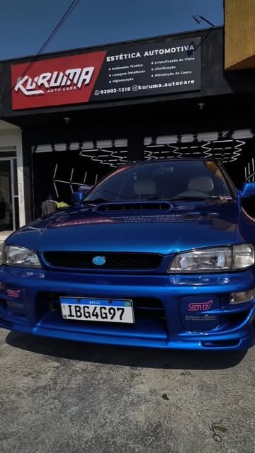 Subaru Impreza azul estacionado em frente à fachada da Kuruma